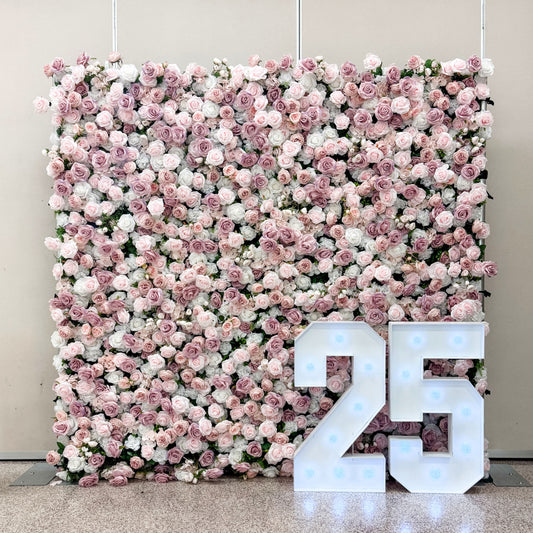 Floral wall with pink and white flowers and illuminated number '25'